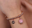 Bracciale Amo Capri  3571662 in metallo con campanella rosa con cristalli e scritta capri rosè